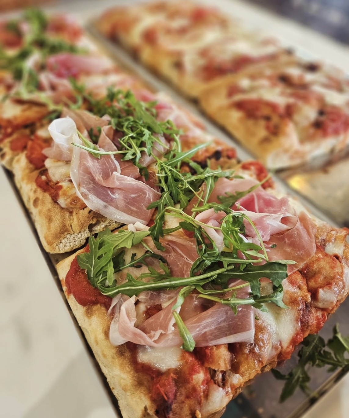 Pinsa topped with Parma ham and rocket
