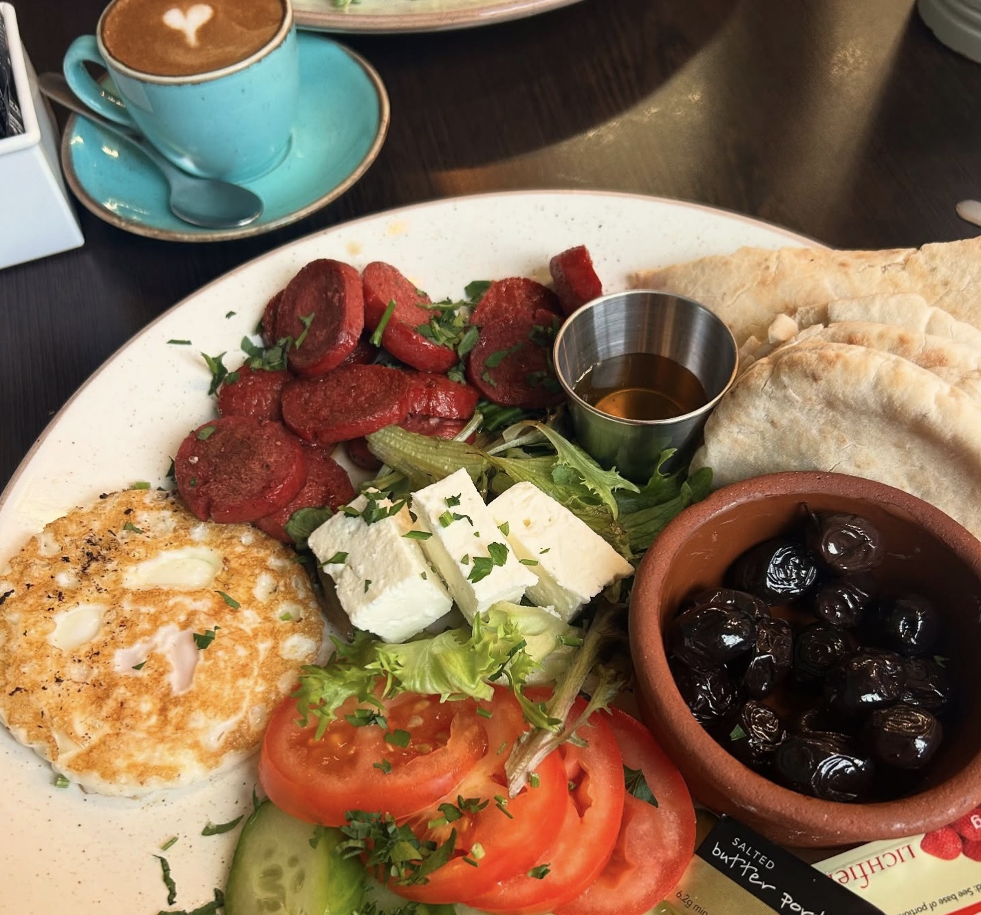 A Turkish breakfast plate with sucuk, feta and olives